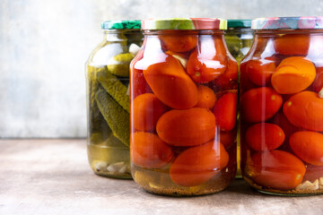 Pickled cucumbers and tomatoes in jars.
