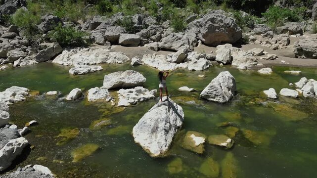 Circling gracefully over Tinipak River, Tanay Rizal, the camera captures a woman posing on white river rocks&mdash;mostly showing her back and adding mystery against the gentle flow of water.