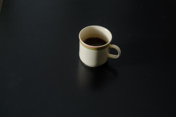A cup of freshly brewed strong and black homemade coffee for a good mood