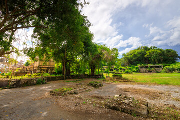 Deserted field with a few trees and a building in the background