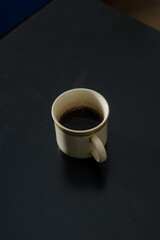 A cup of freshly brewed strong and black homemade coffee for a good mood