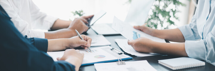 Panorama of corporate teamwork with people discussing financial reports, pointing at charts, planning business strategy, analyzing data and collaborating in office meeting for professional success.