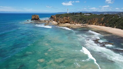 Fototapeta premium Ocean waves breaking on a white sand beach with turquoise emerald colored water on the coast of Australia