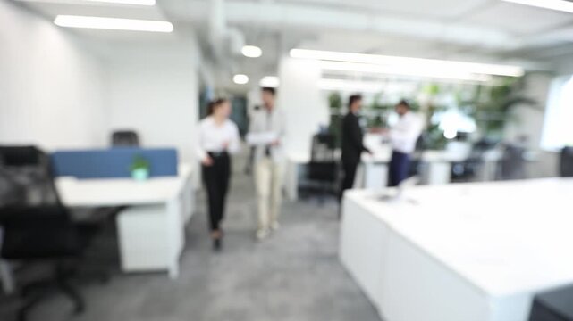 A blurry image of a group of people in a white office