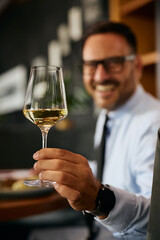 Close up of businessman toasting with wine in restaurant.