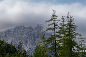 Alpine mountain peaks emerging above a drifting cloud layer