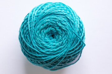 Acrylic yarn for knitting, turquoise, in a ball on a white background