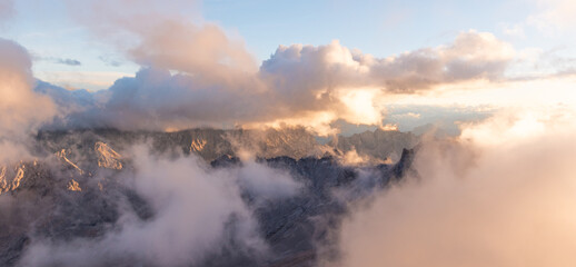 Dramatic alpine cloudscape viewed from the Zugspitze towards the Zugspitzblatt, glowing mountain ridges and rolling clouds at sunrise