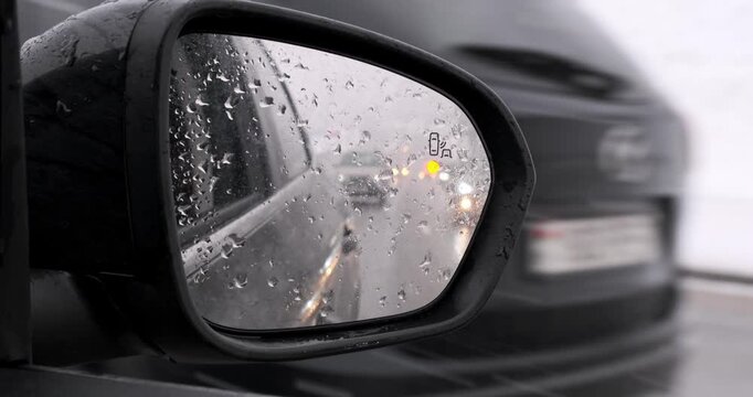 Blind spot monitoring icon on the mirror of a modern car