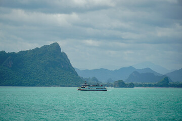 Ferry and Ferry pier near Koh Phangan island in Thailand. The rear of Ferries transport passengers. The beautiful scenery turquoise sea. Big ferry ship with Thai flag turning at the sea and sails.