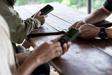 A group of people sitting together but focused on their own smartphones, showing modern lifestyle and digital communication habits