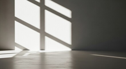 Sunlight streams through a window casting geometric shadows on the wall and floor of an empty room.
