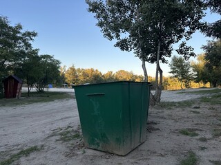 Green large trash cans on the beach