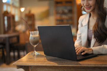 Young businesswoman working on a laptop at a cozy cafe