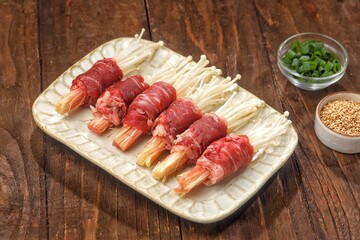 Raw Beef enoki roll is a rolled sheet of beef filled with enoki mushrooms.