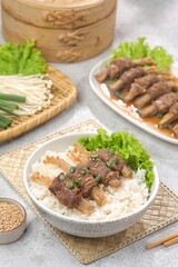 Beef enoki roll is a rolled sheet of beef filled with enoki mushrooms.