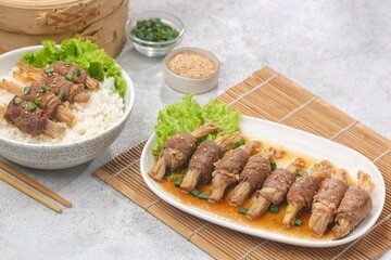 Beef enoki roll is a rolled sheet of beef filled with enoki mushrooms.