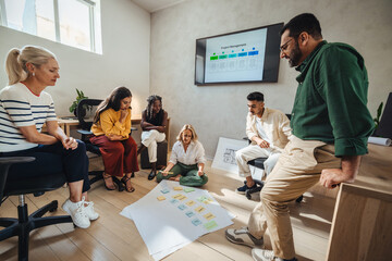Collaborative meeting of diverse young professionals discussing project ideas