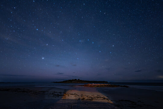 Night sky on the coast in Brittany, with a nearby island