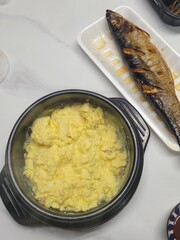 Steamed Korean egg dish, Gyeran Jjim, known for its light, fluffy texture. Served hot, often in an earthenware pot, this savory and comforting dish pairs well with rice and banchan.