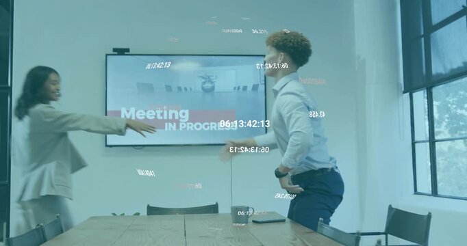 Man pushing back chair greeting woman and placing laptop on conference table for business meeting