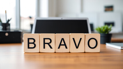 Word BRAVO on wooden cubes on an office desk, a business concept