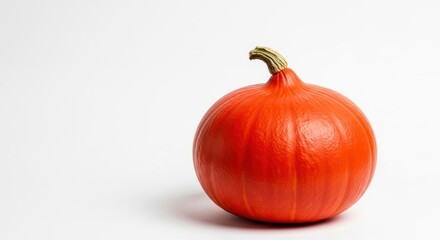 Bright orange hokkaido pumpkin against a clean white studio background