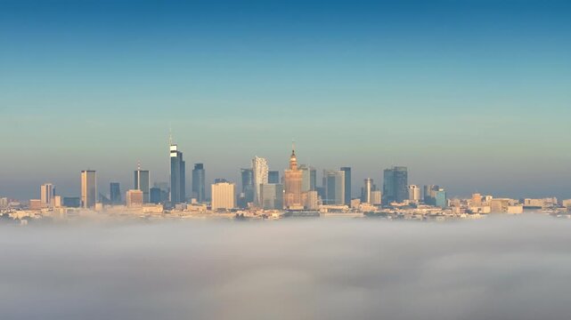 Panorama Warsaw city at sunrise. Drone time-lapse cityscape downtown skyscrapers modern architecture high-rise buildings on horizon covered with rolling clouds of fog, top view cityscape over clouds