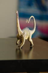 Two figures of Triceratops and Diplodocus dinosaurs on a black table that children like to play with and remind us of the creatures that once lived on Earth