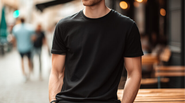 Man in a blank black t-shirt mockup standing outdoors on a blurred city street