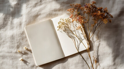 Open book with blank pages rests on a table, flanked by dried floral arrangements. Generative AI image