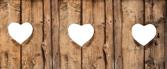 old wooden plank background with three heart shapes holes on a transparent background