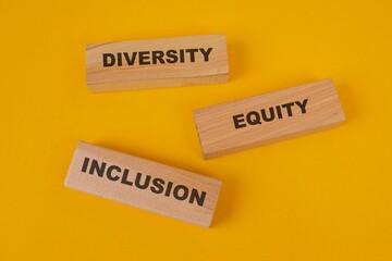 Diversity, Equity And Inclusion On Wooden Blocks Over Yellow Background