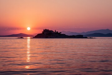 Fototapeta premium Serene Island Silhouette at Sunset Over Calm Water.