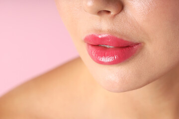 Obraz premium Woman with beautiful lipstick on her lips against pink background, macro view