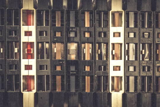 Closeup of many, paralell arranged vintage audio tapes. Top down view. Grainy, warm Background for retro music theme.