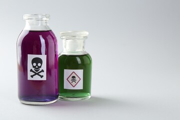 Bottles of poison with warning sign on light background. Space for text