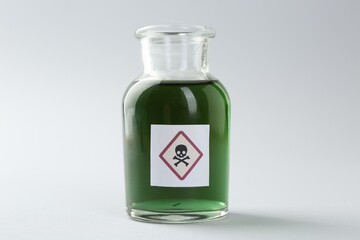 Bottle of poison with warning sign on light background