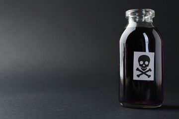 Bottle of poison with warning sign on grey background, closeup. Space for text