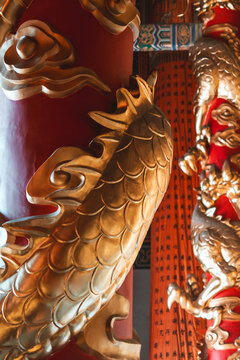 View of the gilded dragon writhes around a crimson pillar, its scales shimmering in the soft light, a testament to ancient craftsmanship, Dali, Yunnan, China.