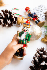 Festive Christmas nutcracker in hand with decorations and pinecones