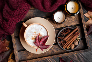 Cozy autumn composition with coffee, plaid and maple leaves