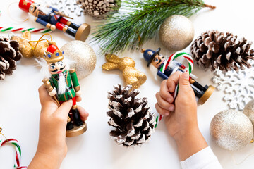 Child hands decorating with nutcracker and Christmas ornaments