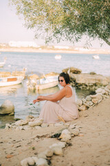 A woman in a long dress walks along the coast, boho style