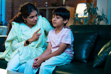 Indian Mom gently scolds child while teaching good habits, showing care and parenting indoors