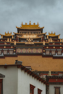 View of the Songzanlin Monastery's golden roofs against the moody sky, displaying the intricate detail of Tibetan architecture, Di Qing Zang Zu Zi Zhi Zhou, Yun Nan Sheng, China.