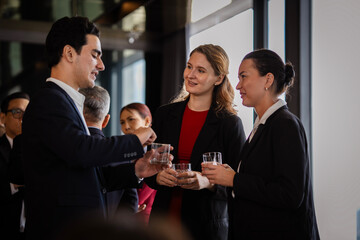 Informal networking among professionals in a social party, demonstrating teamwork, motivation, and workplace culture.
