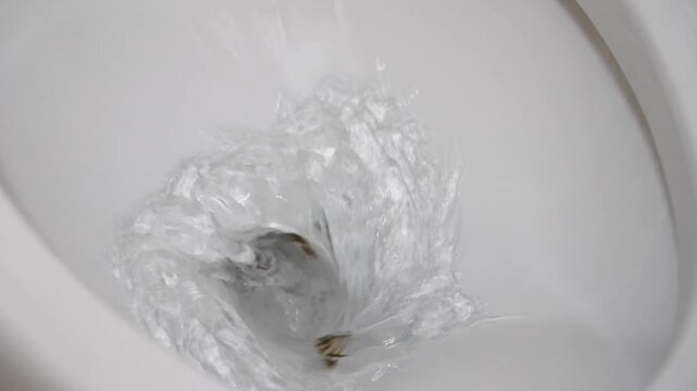 Flush toilet. Water flushes the toilet. Water saving concept. Slow motion