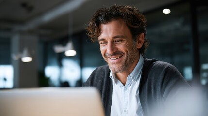 smiling young man working on a laptop in the office handsome, mature male businessman smiling while using his computer at his work desk.
