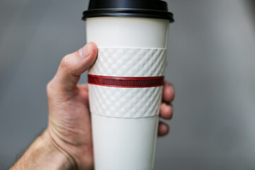 Hand holding a cup of coffee